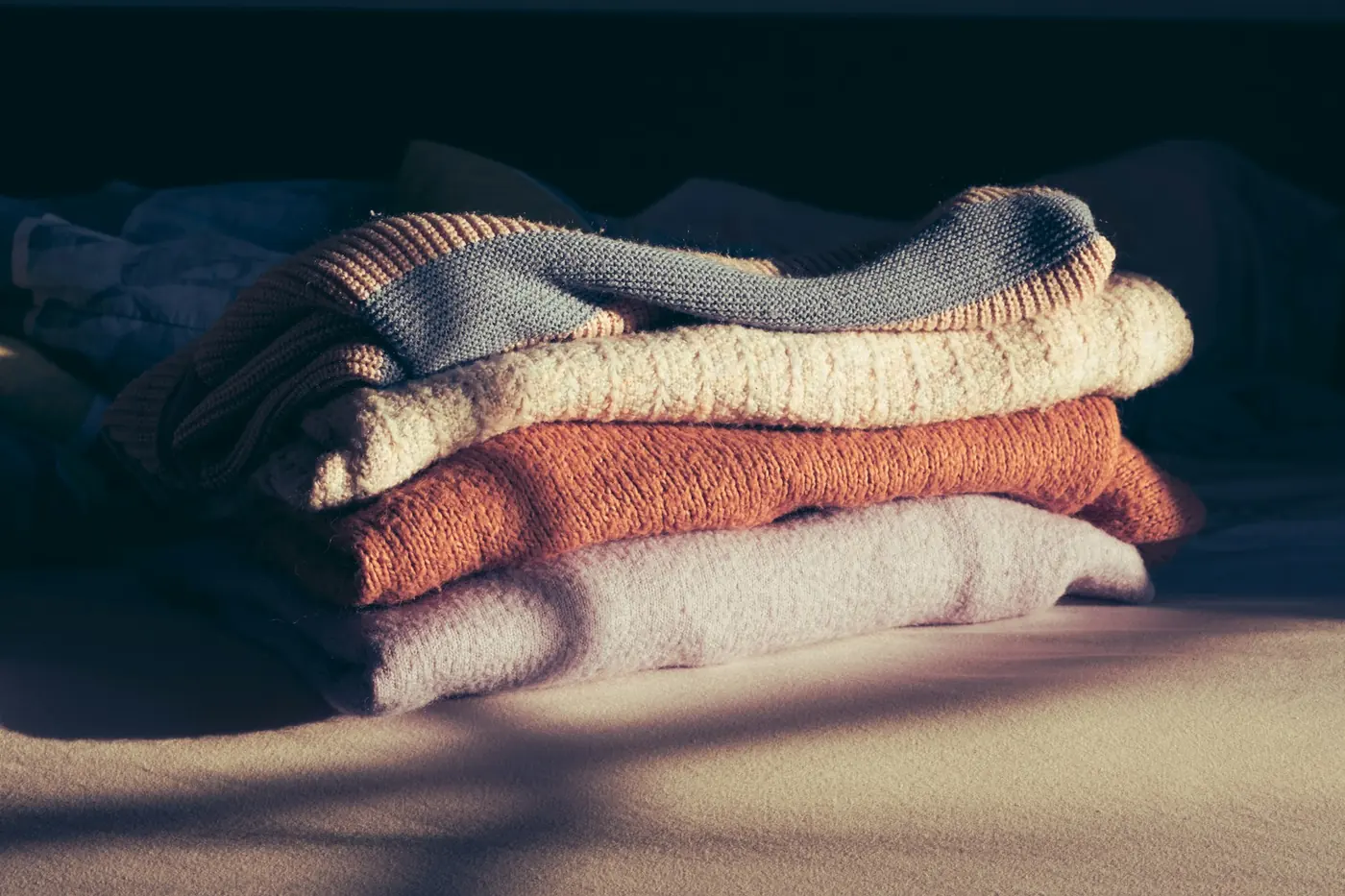 A stack of neatly folded knitwear and blankets
